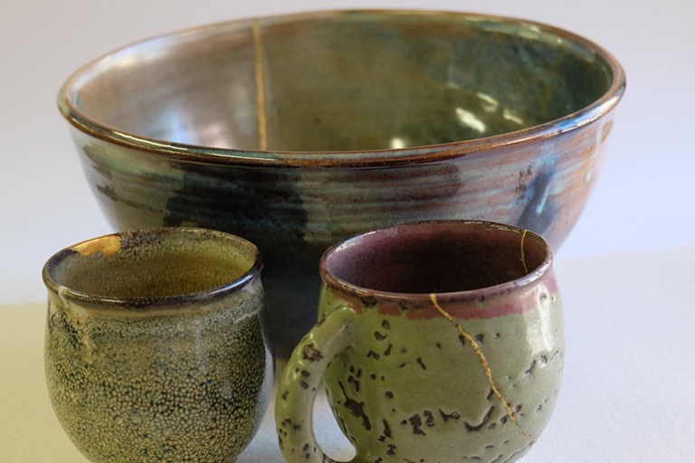 Bol et tasses en céramique réparés au kintsugi, veines d'or